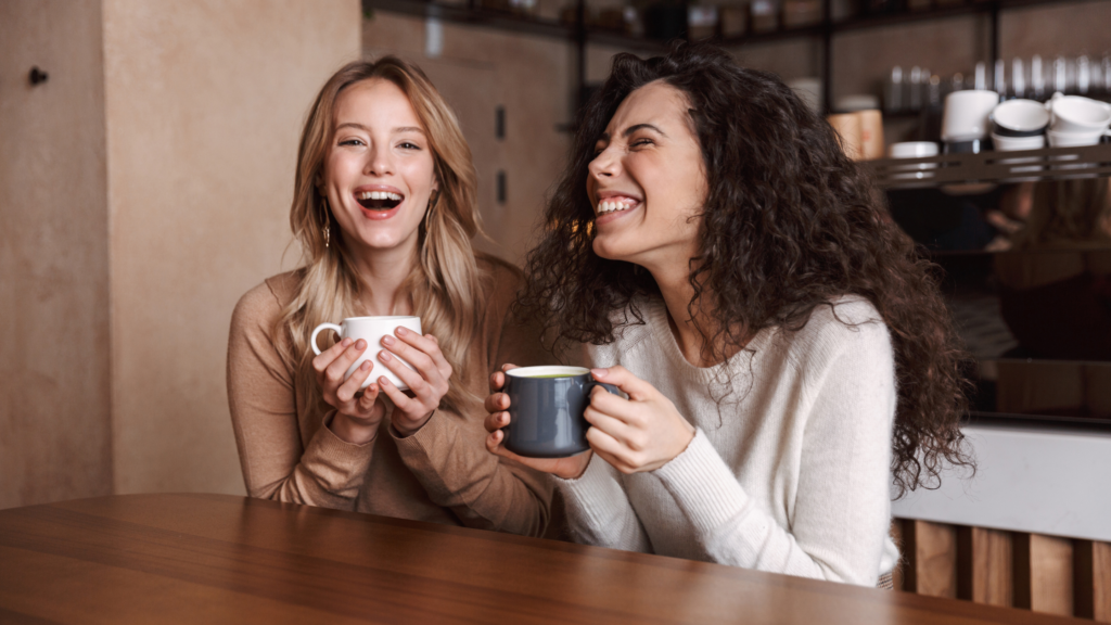 two people laughing over coffee